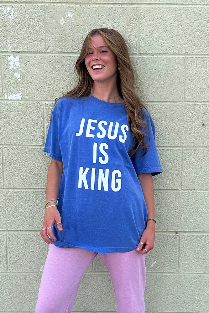 Smiling woman wearing the blue Jesus Is King tee