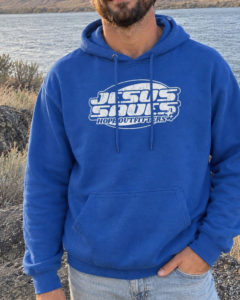 Jesus Saves Retro Hoodie - close-up of the Royal blue hoodie's white Jesus Saves print worn by a bearded man by the Columbia River