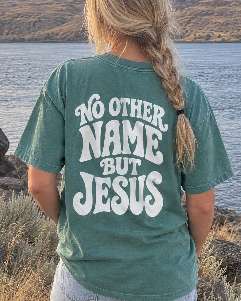 No Other Name But Jesus Tee - close-up of the No Other Name But Jesus back print worn by a blonde woman facing the Columbia River