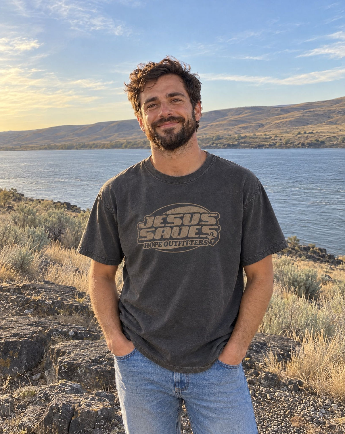Jesus Saves Retro Tee - bearded man standing on a basalt ledge by the Columbia River in the graphite tee