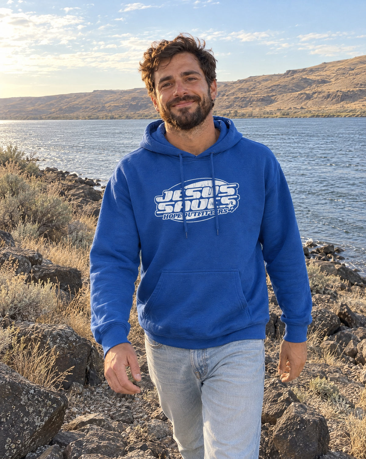 Jesus Saves Retro Hoodie - bearded man walking along basalt rocks by the Columbia River in the Royal blue hoodie