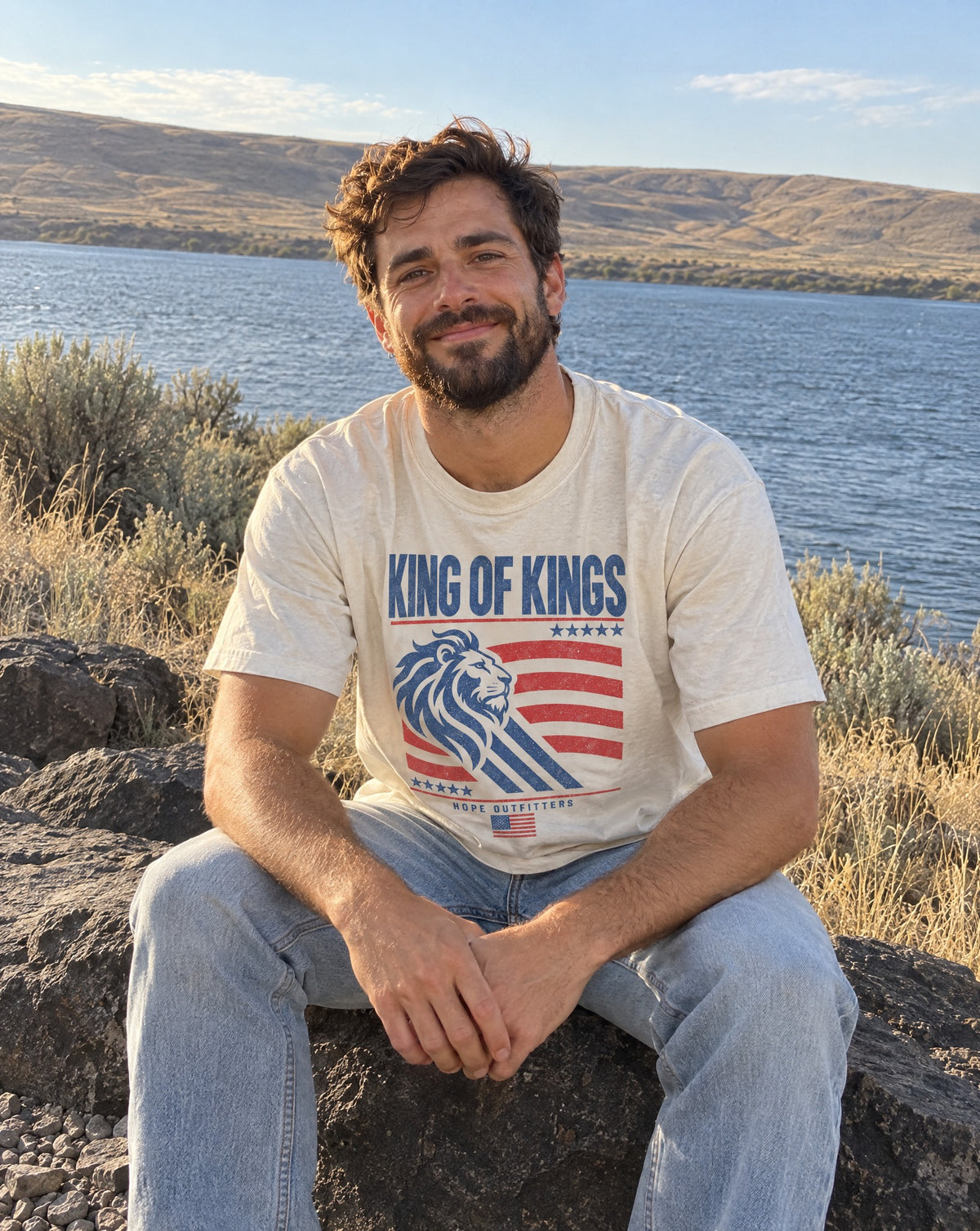 King of Kings Lion Tee - bearded man sitting on a basalt ledge above the Columbia River in the ivory tee